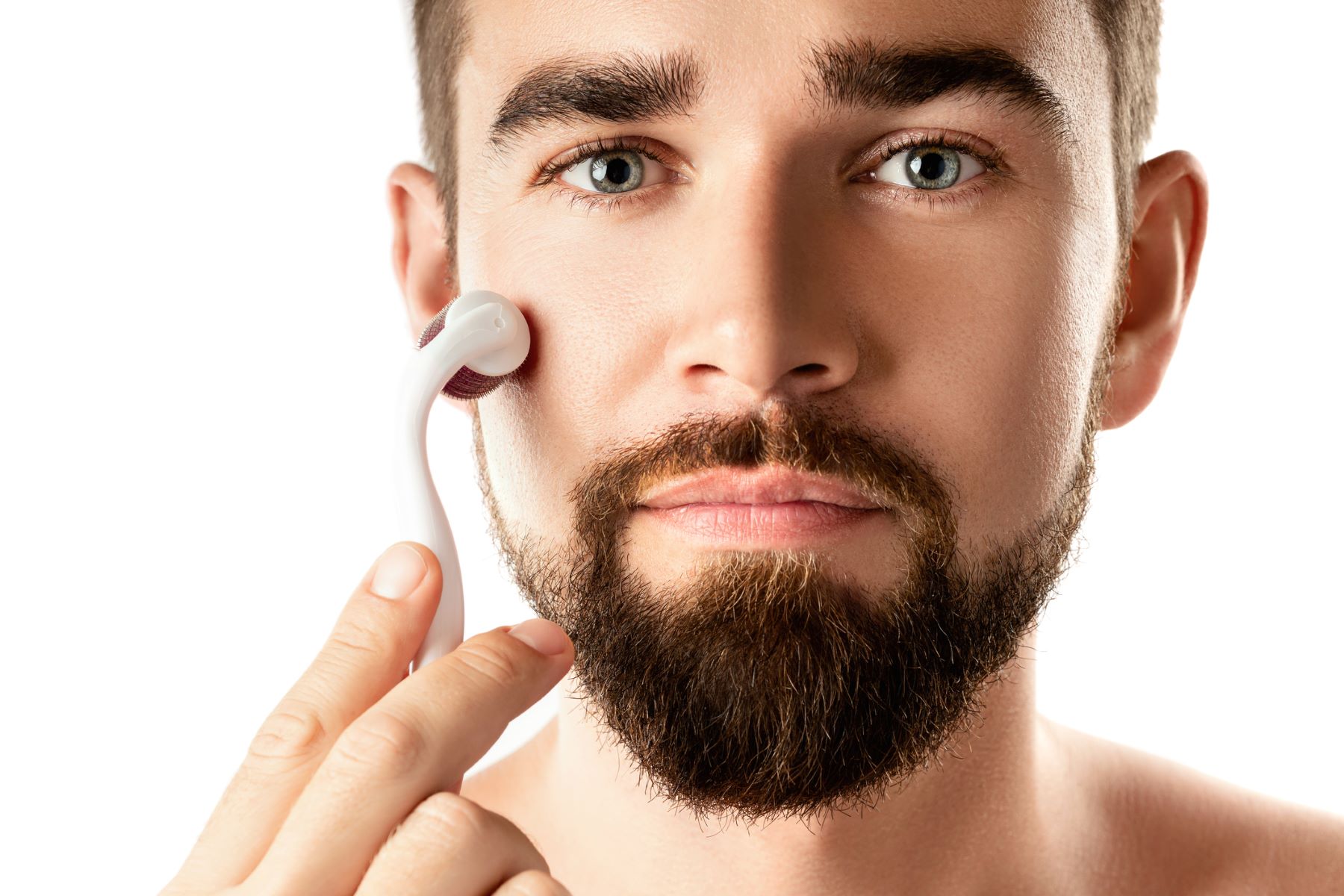 Man using a beard roller for beard growth