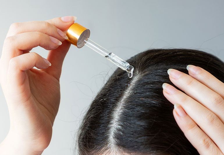 Woman apply treatment to dry hair