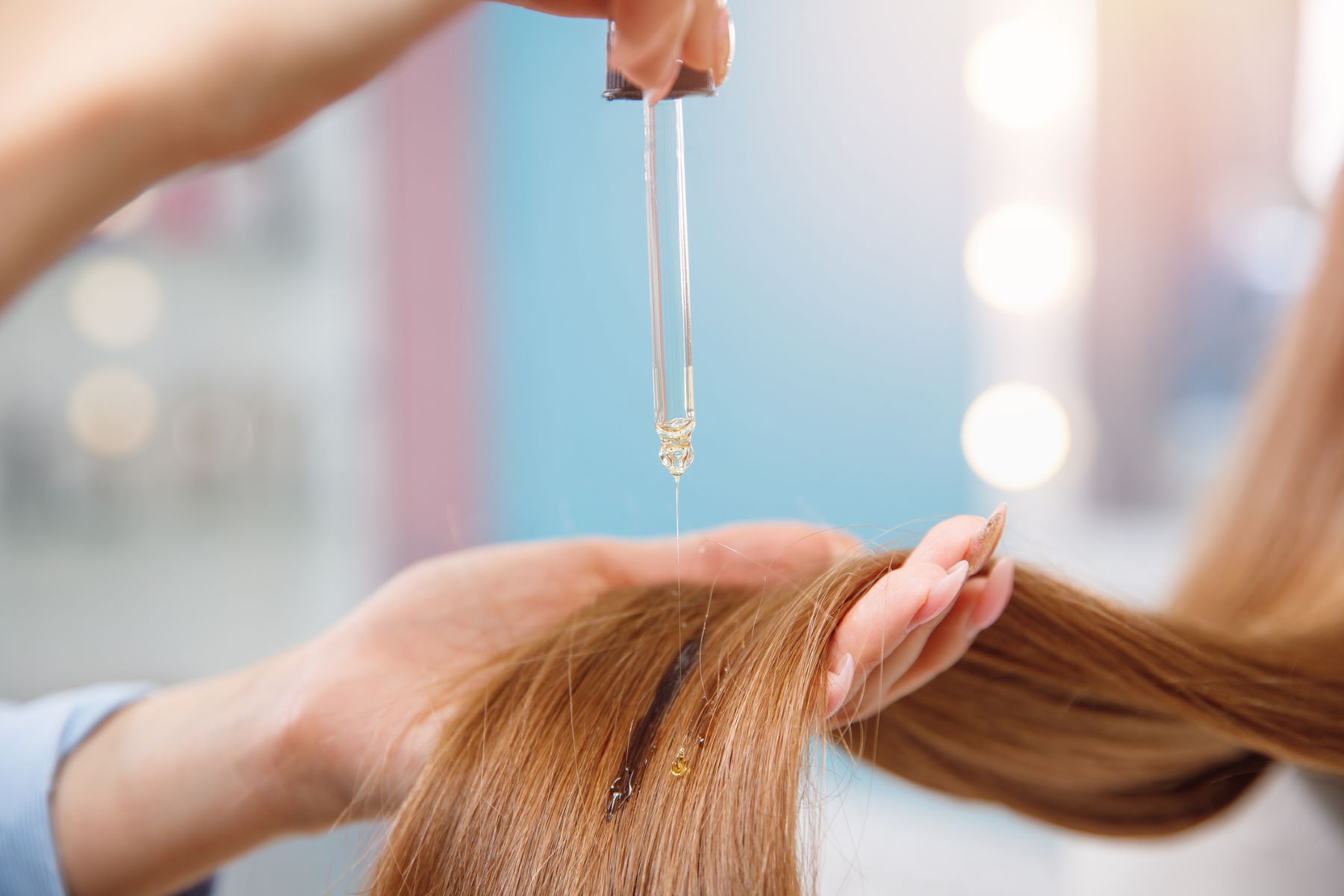 Woman using hair oil to prevent hair loss from vaping