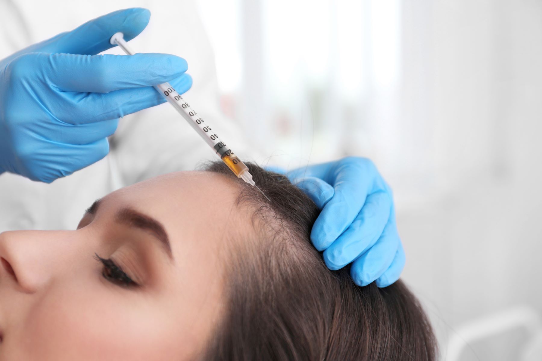 Female patient getting scalp anaesthesia before a cosmetic procedure