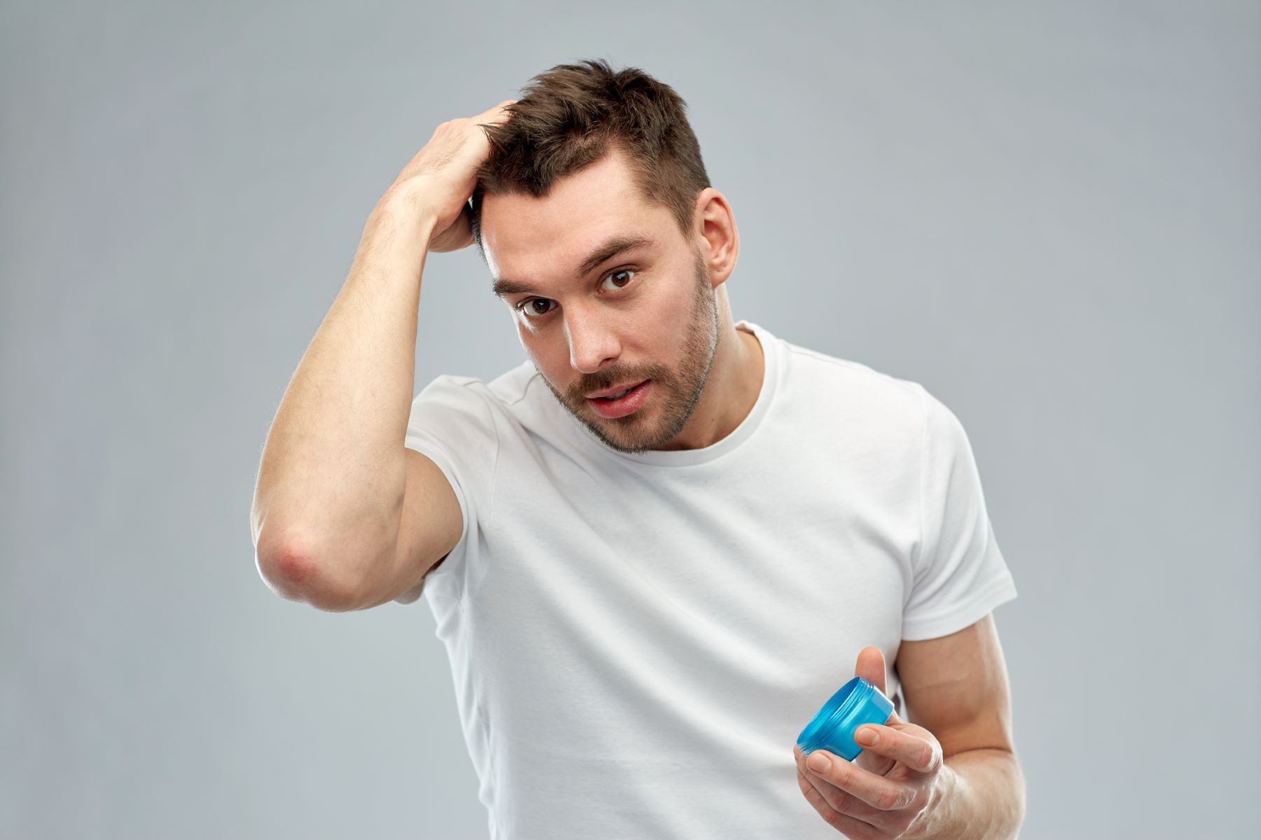 Man styling hair with hair spray alternatives