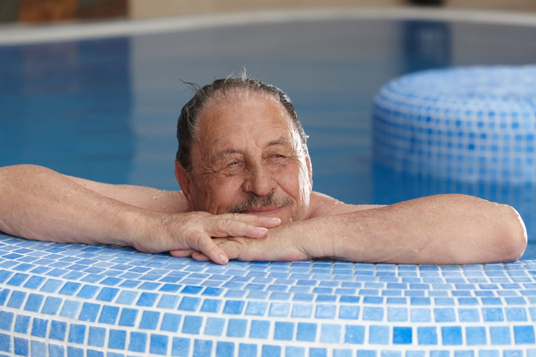 Senior man lowering his stress level in the pool