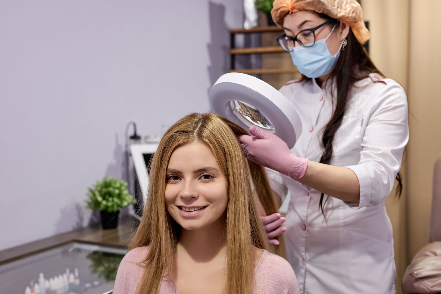 Trichologist examining hair with a dermatoscopy