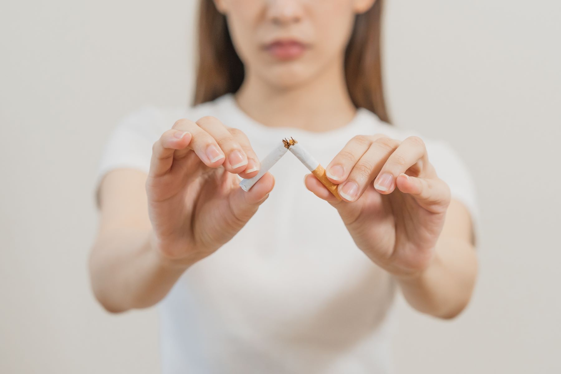 Woman who quit smoking breaking a cigarette