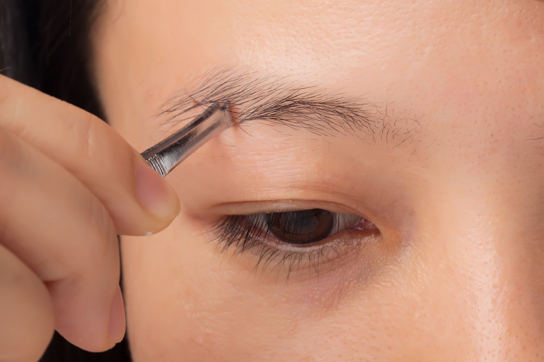 Woman overplucking her eyebrows