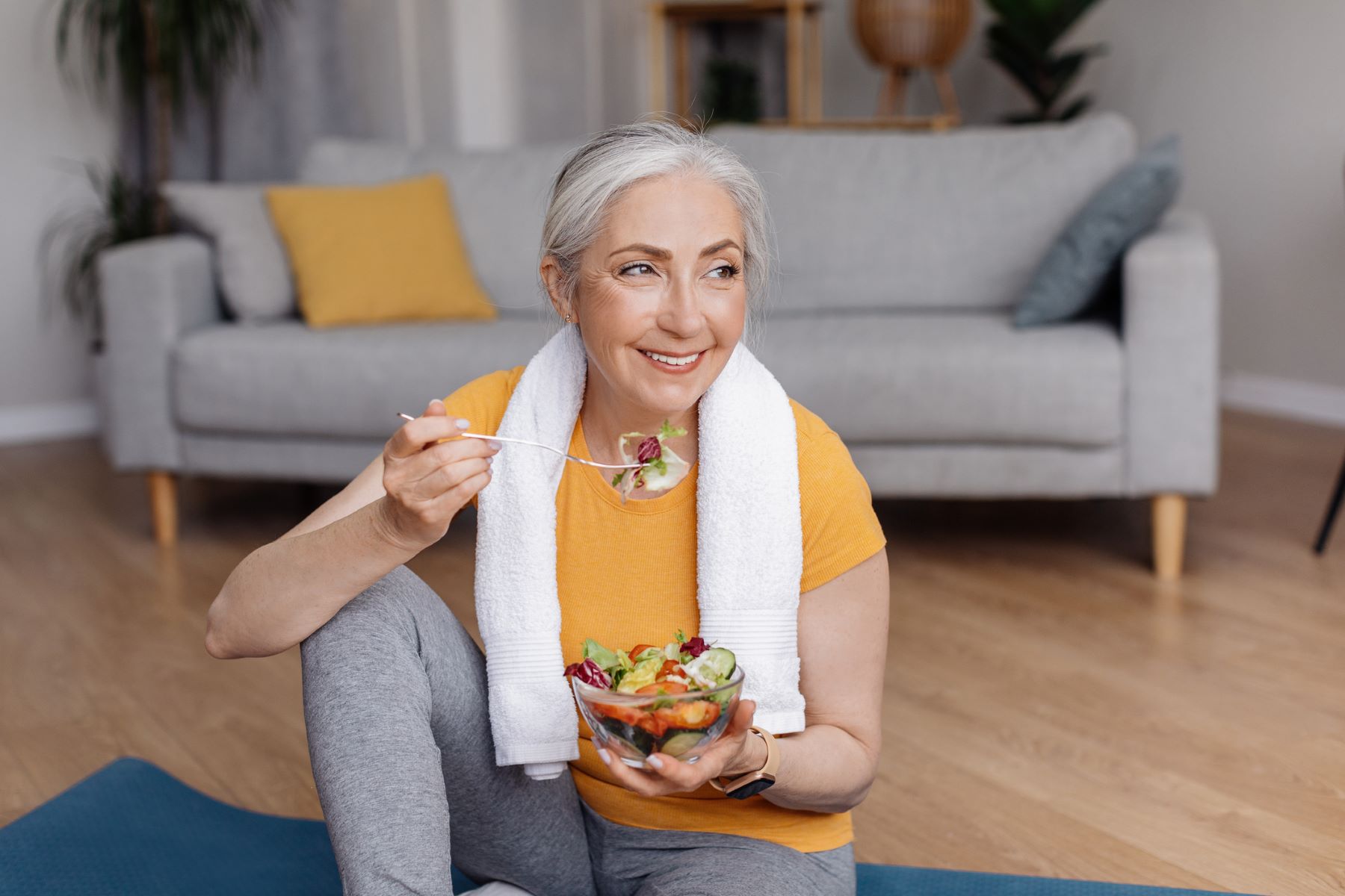 Woman with grey hair eating a healthy meal