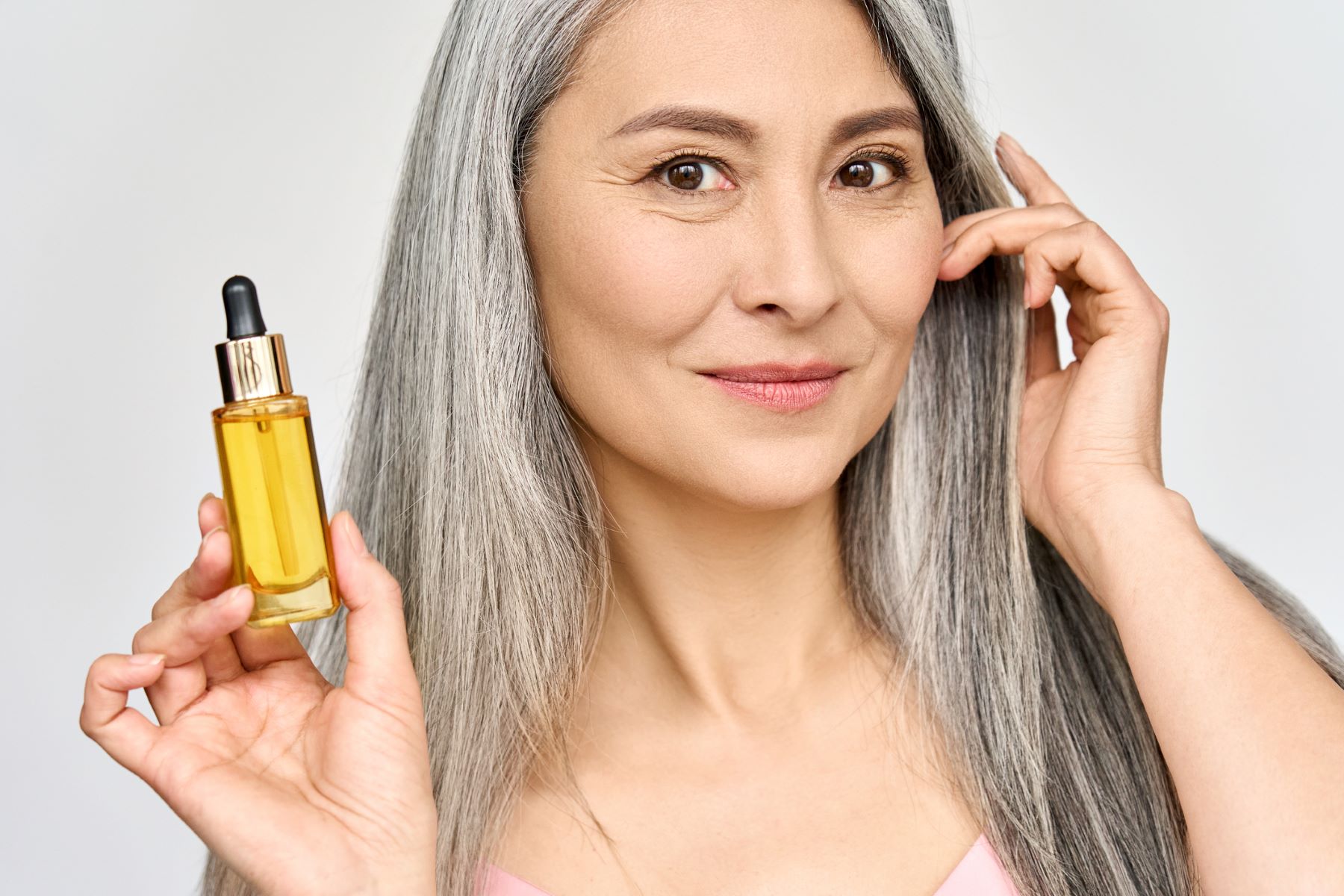 woman using essential oil to moisturise her hair