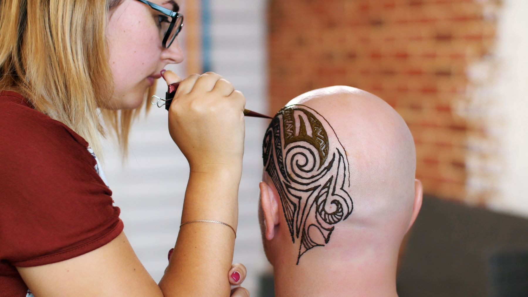 Cancer patient getting a henna scalp tattoo