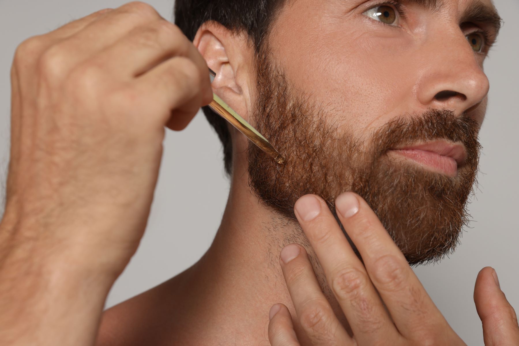 Man using black seed oil on his facial hair