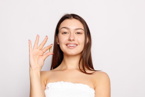 Woman holding a pumpkin seed oil capsule