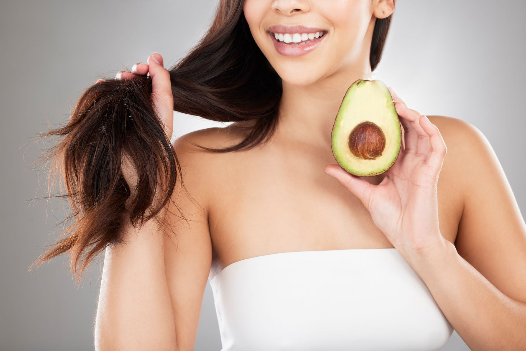 Woman using avocado for its hair benefits