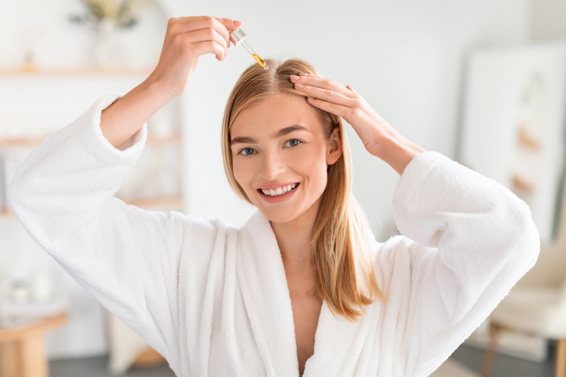 Woman using hair oil to prevent Minoxidil hair shedding