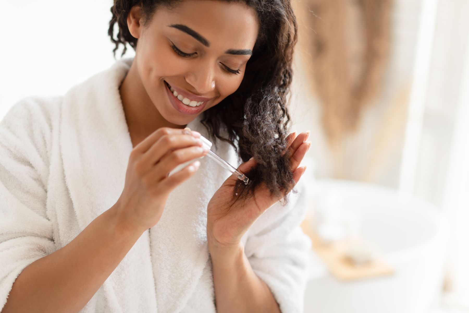 woman moisturising her hair with essential oil