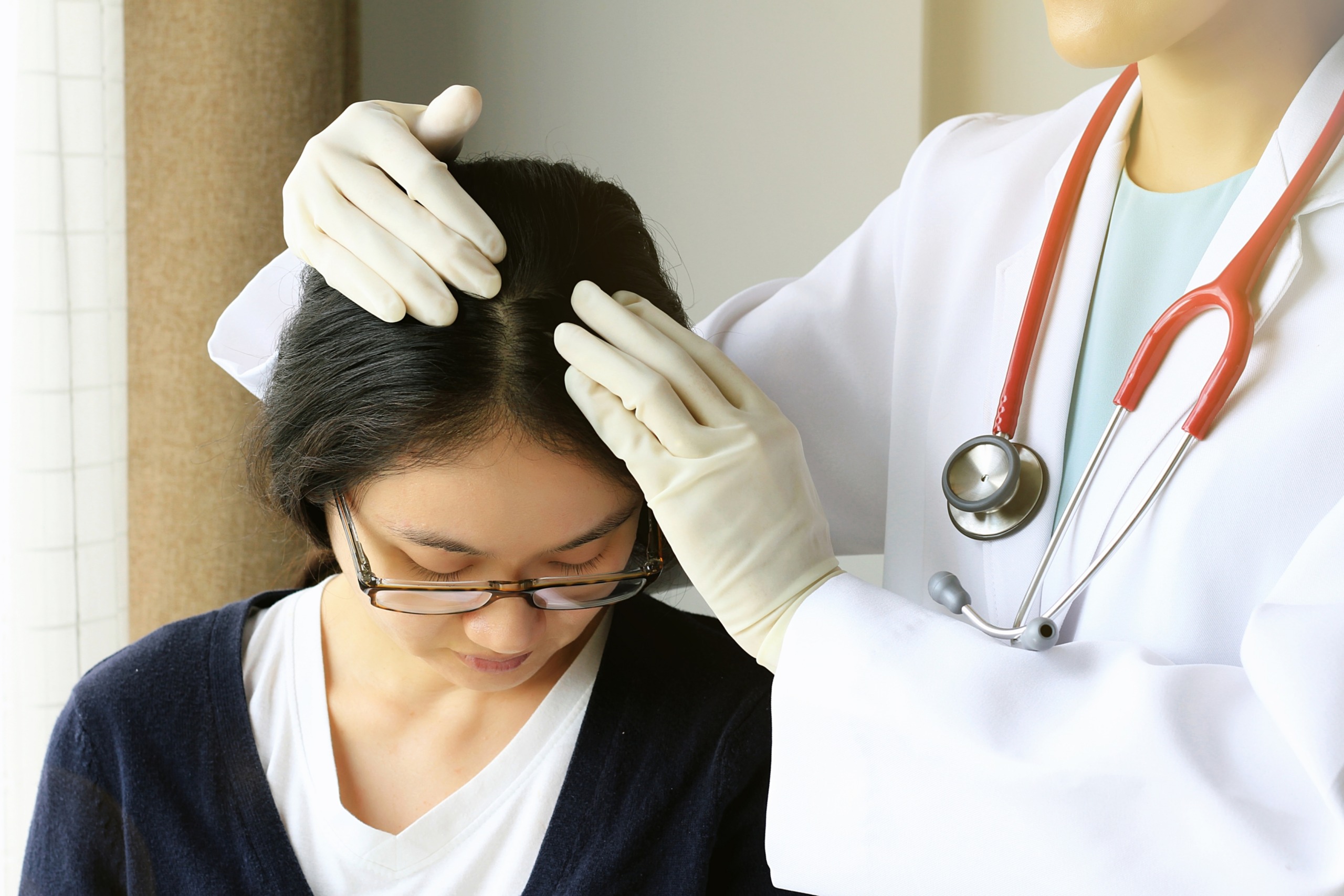 Woman being examined for female hair loss by a trichologist