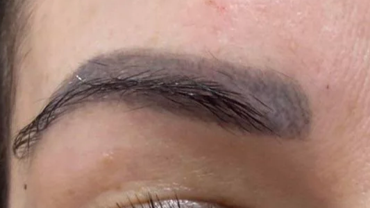 Eyebrow colour fading with contrast to natural brow colour.