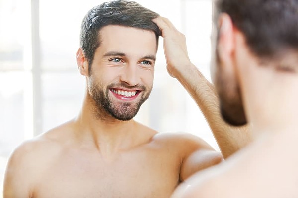 Man admiring successful hair transplant